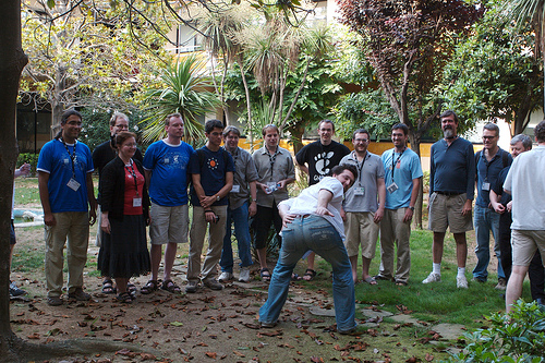 A lot of people posing for a photo outdoors with Jeff in the middle, presenting his pants of thanks on